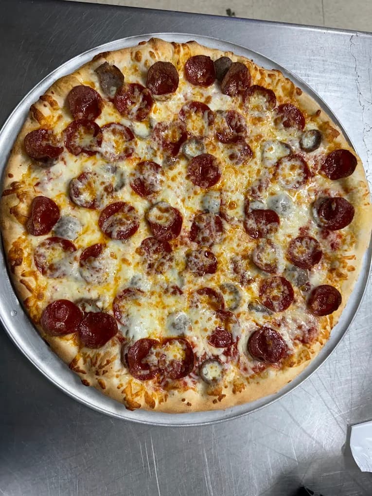 A pepperoni pizza with melted cheese on a metal serving tray